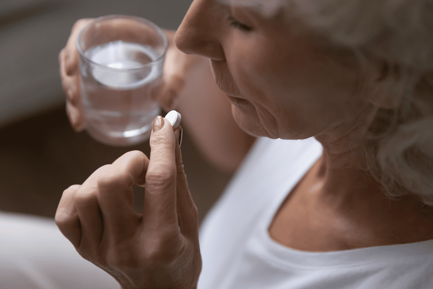 Older woman taking painkiller