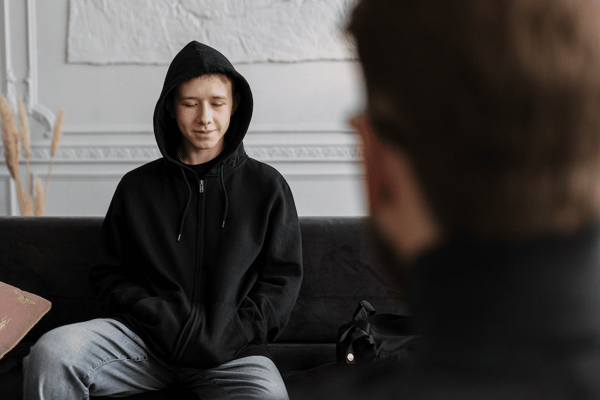 Young man in hoodie with therapist